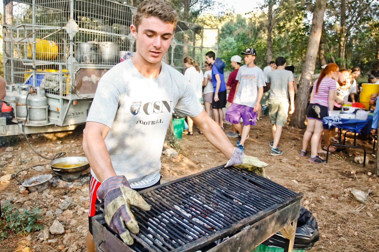 Teen carrying a grill in a kibbutz in Israel